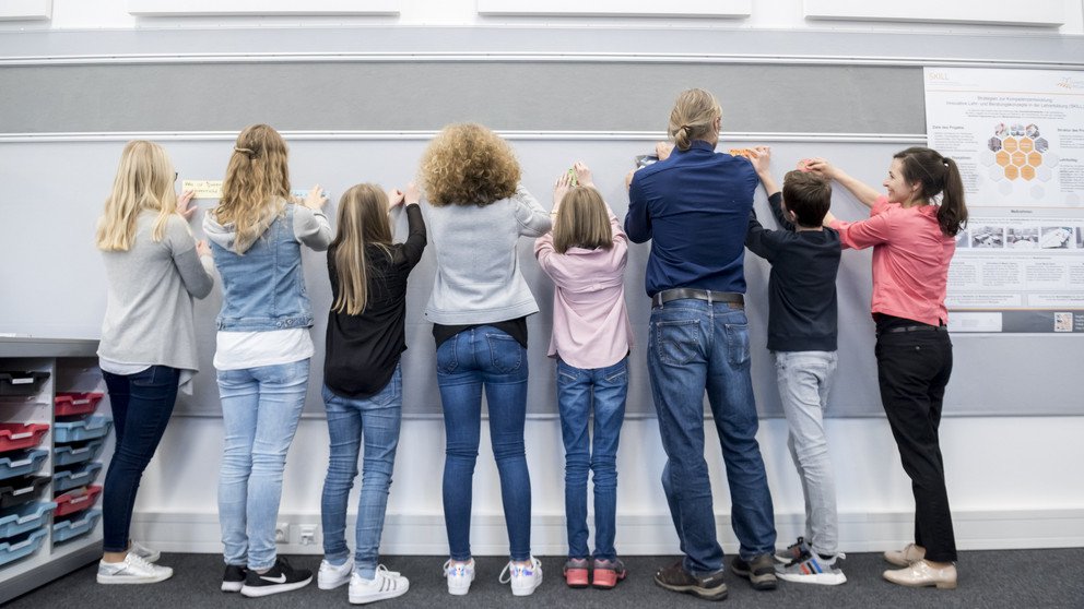Lehrende und Lernende arbeiten gemeinsam an einer Pinnwand (Foto: Universität Passau: CC BY 4.0: https://creativecommons.org/licenses/by/4.0/)