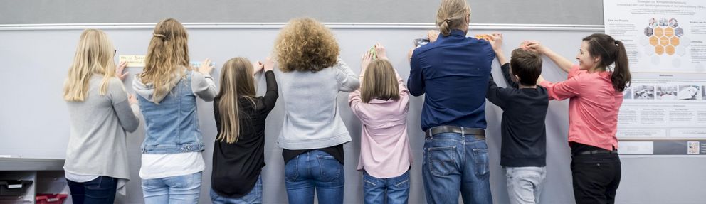 Lehrende und Lernende arbeiten gemeinsam an einer Pinnwand (Foto: Universität Passau)